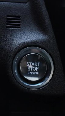 Parmak 'ın dikey videosu motoru çalıştırmak için düğmeye basın. Sürücü eli arabanın çalıştırma düğmesine basıyor. Araba motorunu çalıştırıyorum. Düğmeye kadar takip et. Ulaşım ve teknoloji kavramı
