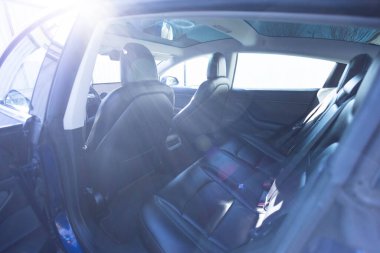 Arabanın tavanında kapak var. Arabada panoramik cam güneş çatısı var. İçeriden gökyüzüne kadar temiz cam ve manzara. Renkli camlı duble sunroof kapağı. Modern lüks elektrikli arabanın arka deri koltukları..