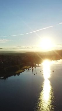 Maggiore Gölü 'ndeki Arona Kasabası' nın dikey videosu. İtalya Feribot Teknesi. Dağlar ve Maggiore Gölü ile çevrili bir şehir. İtalya Maggiore gölü manzaralı dar bir sahil. Gün doğumunda..