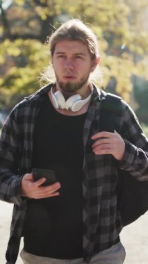 İnsanoğlunun akıllı telefonunu kullandığı dikey format videosu. İlerici Teknoloji. Sosyal ağ. Seyahat yaşam tarzı. Telefonlar. Uygulamalar. Sırt çantalı gezgin Büyük Şehir 'de yürüyor..