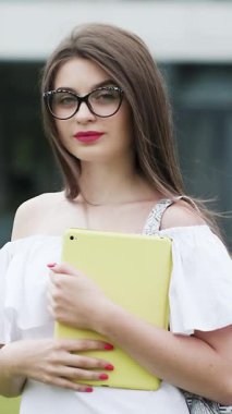 Dikey Format Video Portre genç çekici kadın kameraya bakın şehir merkezinde mutlu moda kızı yaz yüz teknolojisi güzel yavaş çekim