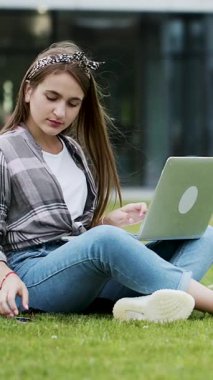 Öğrencinin internet üzerinden akıllı telefon aldığını gösteren dikey biçim videosu. Haberleri kontrol ediyorum. Genç bayan esmer çekici. Telefonları ekranın dışında tutuyor..