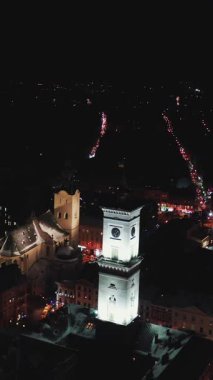 Antik şehrin Panorama 'sının dikey format videosu. Ukrayna Lviv Belediye Meclisi, Belediye Binası. Eski binaların çatıları. Hava görüntüsü. Gece vakti. Kış