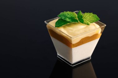 Krem şantili süslemeli tatlı. Panna cotta tropik vanilyalı panna cotta, mango guguk kuşu, mango-tutku meyveli mus. Küçük bardakta çikolatalı mus panna cotta.