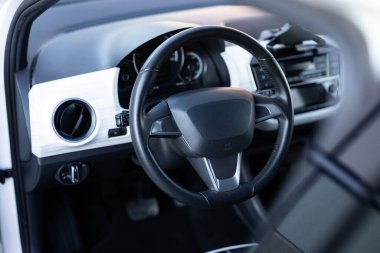 Siyah deri gösterge paneli, klima kontrolü, hız göstergesi, ekran, dekorasyon. Direksiyon simidi. Direksiyon simidi olan elektrikli bir araba..