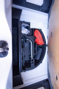 Bagajda yangın söndürücü ve lastik enflasyonu onarım kiti var. Lüks bir arabanın bagajında ilk yardım çantası ve ilk yardım çantası. Bir araba bagajında tekerlekleri şişirmek için kompresör