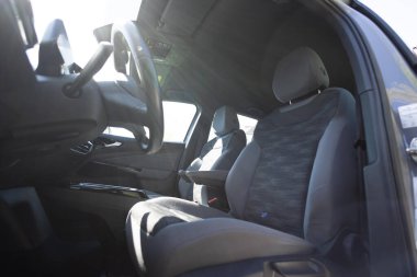 Prestijli modern elektrikli araba. Arabanın içinde deri koltuklar, direksiyon, pencereler, konsol, vites kolu, elektrik düğmeleri, dijital hız göstergesi var. Elektrikli arabanın içi. Araba temizleme