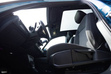 Yeni elektrikli arabanın panoramik cam güneş çatısı. İçeriden gökyüzüne kadar temiz cam ve manzara. Renkli camlı sunroof kapağı. Otomotiv sunroof 'u. Arabanın çatısında kapak var..