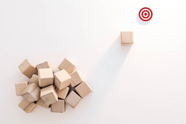 Beyaz Arkaplanda Tek Blok ve Kırmızı Hedef olan Tahta Bloklar Yığını. Liderlik ve Girişim. Kalabalığın dışında durmak..