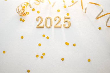 Altın 2025 yılbaşı arifesi konfeti ve kurdeleyle kutlanıyor. Beyaz Arkaplan.