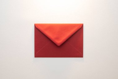 Beyaz arka plana yerleştirilmiş tek bir kırmızı zarf..