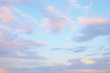 Sabahın erken saatlerinde ya da öğleden sonra sakin bir manzarada yumuşak pastel bulutlar açık mavi bir gökyüzünde sürükleniyor..