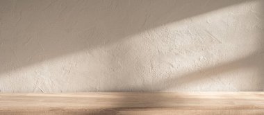 Yumuşak güneş ışığı, pürüzsüz ahşap bir yüzey ve dokulu bir duvar üzerine gölge düşürür. Öğleden sonra boyunca sakin ve davetkar bir atmosfer yaratır..