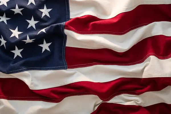 Amerikan bayrağı hafif hafif esintide dalgalanır, canlı renklerini sergiler. Bu, açık hava festivalinde vatanseverliğin ve birliğin özünü yansıtıyor..