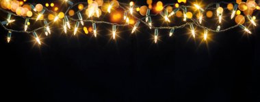 Twinkling string lights hang against a dark backdrop, illuminating the space with a soft glow perfect for evening gatherings and celebrations. The warm hues enhance the festive atmosphere. clipart