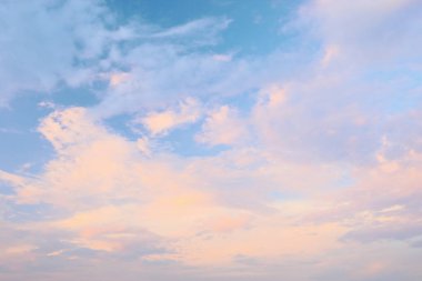 Sabahın erken saatlerinde ya da öğleden sonra sakin bir manzarada yumuşak pastel bulutlar açık mavi bir gökyüzünde sürükleniyor..