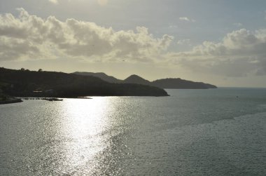 Karibik güneş, ufuktaki dağlardan gelen suyu yansıtıyor. Yüksek kalite fotoğraf