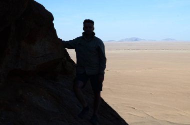 Man mirabib silueti Desert Panorama 'daki yalnız manzaralı Granit Kayası. Yüksek kalite fotoğraf