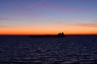 Karanlık günbatımında ufukta bir gemi var. Yüksek kalite fotoğraf