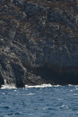 Dalgalar, Yunan Kalymnos adasındaki kayalara vuruyor. Yüksek kalite 3d illüstrasyon