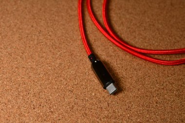 Kork yüzeyinde siyah mavisi olan USB C kablo kırmızı. Yüksek kalite fotoğraf