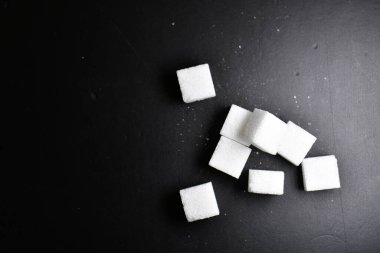 Şeker küpleri, siyah arka plan, aydınlatılmış tatlı yiyecekler. Yüksek kalite fotoğraf