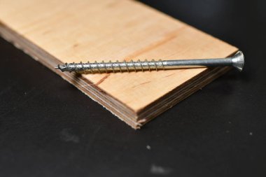 Siyah Ply Wood gümüş metalini vidalayın Kara Arkaplan Copyspace. Yüksek kalite fotoğraf