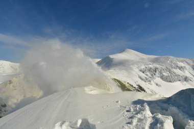 Kış manzarası karla kaplı dağdan yükselen duman. Tokachi volkanı, Hokkaido, Japonya. Yüksek kalite fotoğraf