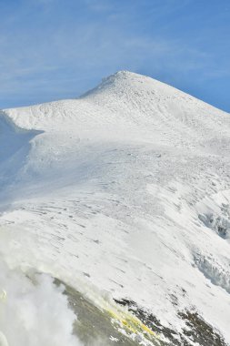Kış manzarası karla kaplı dağdan yükselen duman. Tokachi volkanı, Hokkaido, Japonya. Yüksek kalite fotoğraf
