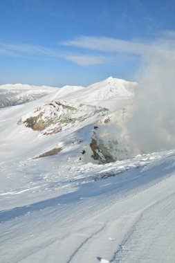 Kış manzarası karla kaplı dağdan yükselen duman. Tokachi volkanı, Hokkaido, Japonya. Yüksek kalite fotoğraf