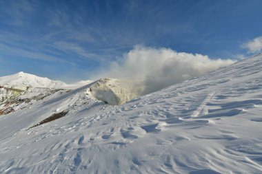 Kış manzarası karla kaplı dağdan yükselen duman. Tokachi volkanı, Hokkaido, Japonya. Yüksek kalite fotoğraf