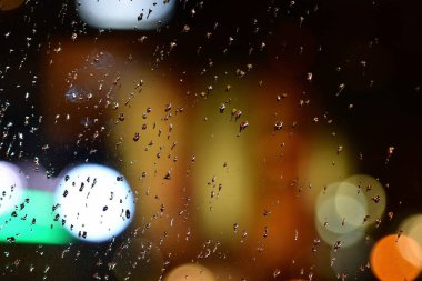 Pencereye düşen yağmur damlaları gece sokaklarını ıslatıyor. Yüksek kalite fotoğraf