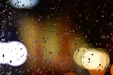 Pencereye düşen yağmur damlaları gece sokaklarını ıslatıyor. Yüksek kalite fotoğraf