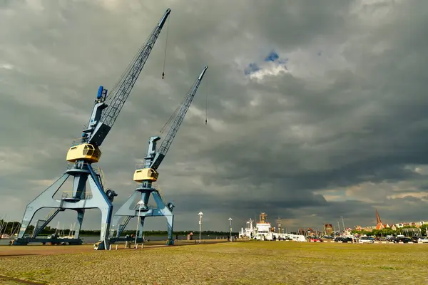 Rıhtım iskelesindeki vinçler Almanya kıyılarındaki eski bir arka plan. Yüksek kalite fotoğraf