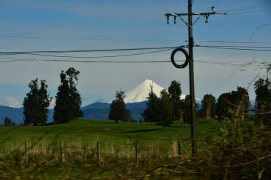 Osorno Vulcano with snow cap green meadows Chile. High quality photo clipart