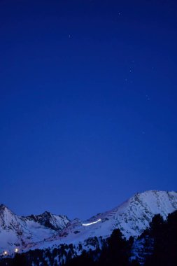 Kışın alacakaranlıkta İsviçre 'nin Kuehtai köyü ve gece kar dağları. Yüksek kalite fotoğraf