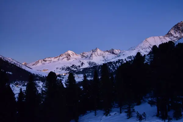 Kışın alacakaranlıkta İsviçre 'nin Kuehtai köyü ve gece kar dağları. Yüksek kalite fotoğraf