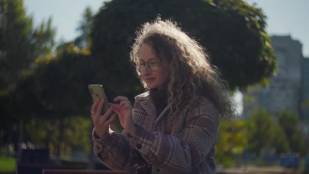 Curly Vrouw Vieren Overwinning Met Behulp Van Telefoon Zitten Het — Stockvideo