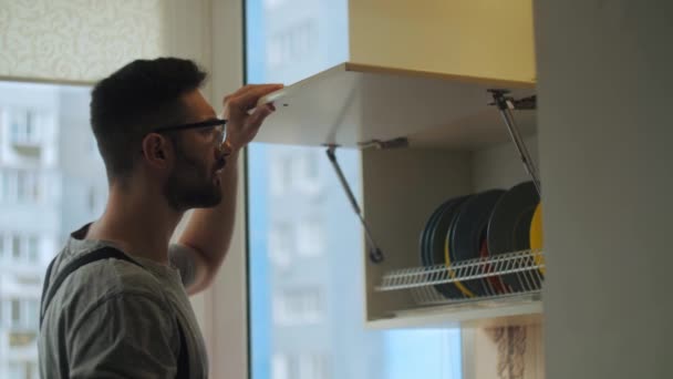 Handyman Opravuje Kuchyňskou Skříň Domácím Bytu Muž Šedém Pracovním Oděvu — Stock video
