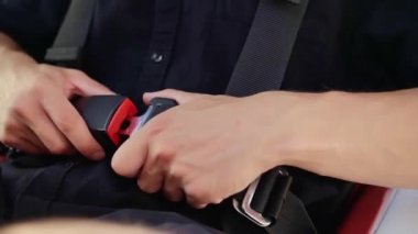 Uçağın pilotu emniyet kemerini takıyor. Uçakta oturan adam emniyet kemerini kapatıyor. Yüksek kaliteli FullHD görüntüler