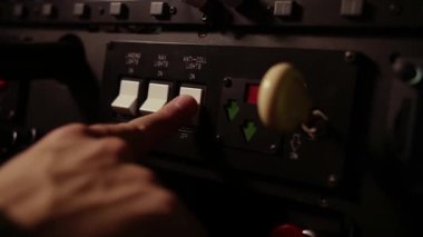 Bir adam uçuş simülatörü eğitimiyle uçaktaki yardımcı elektroniği kapatıyor. Gösterge paneli uçakları. Yüksek kaliteli FullHD görüntüler