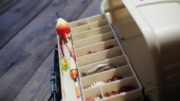 釣りフックのためのボックス 釣りツールを示す男屋外 釣り趣味のための多色のルアーや魚フックのセット 高品質のフルHd映像 — ストック動画