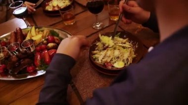 Restorandaki yemek. Bir adam masaya oturur ve tavuklu salata yer. Masada farklı yemekler var. Yüksek kaliteli FullHD görüntüler