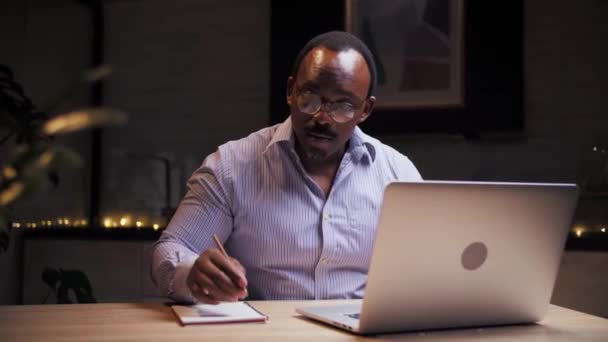 非洲男人在家上网学习 商人用笔记本电脑远程工作 黑人男人在笔记本上写字 在电脑上做远距离教育 高质量的4K镜头 — 图库视频影像