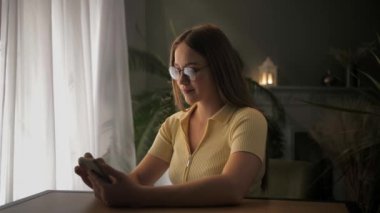 Heyecanlı genç kadın, evinde akıllı telefon tutarak zaferini kutluyor. Aşırı neşeli sarışın kız piyango kazanan piyango oyunu açık arttırması için cep telefonu kullanıyor. Harika zafer konsepti. Yüksek
