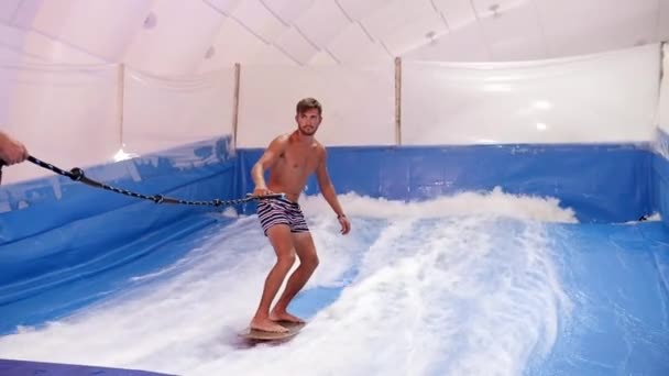 Aantrekkelijke Man Paardrijden Surfplank Golf Simulator Binnen Jonge Surfer Tijdens — Stockvideo