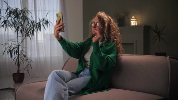 Mulher Faz Videochamada Usando Smartphone Sentado Sofá Jovem Garota Cabelo — Vídeo de Stock