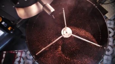 Kahve makinası aroma fasulyelerini karıştırıyor. Depoda taze aroma kafeini üretiyor. Top View büyük kızartma makinesinde kahve yapıyor. Yüksek kalite 4k görüntü