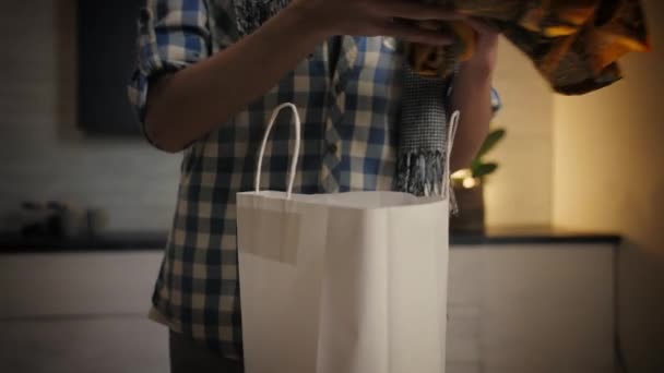 Молодой Человек Распаковывает Одежду Бумажный Пакет Дома Парень Открывает Коробку — стоковое видео