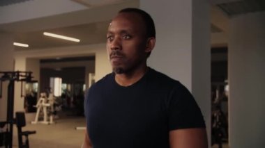 Ciddi Spor Siyah Adam spor salonunda koşu bandında yürüyor. Fitness Genç Adam spor giyim ile kardiyo antrenmanı yapıyor. Kilolu Erkek spor yapıyor. Yüksek kalite 4k görüntü